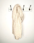 beige blanket scarf hanging of a peg.