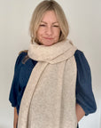 blonde woman wearing denim shirt under a beige scarf