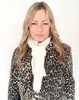 Woman wearing a leopard print coat and cream stripe knitted scarf