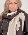 Woman wearing a brown leather jacket and a large scarf with a  Dark Brown & Cream Cow print pattern for Autumn Winter