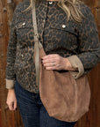 woman wearing a leopard print jacket holding a Dark taupe suede XL crossbody swing bag