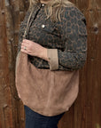woman wearing a leopard print jacket holding a Dark taupe suede XL crossbody swing bag