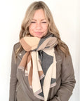 woman wearing a grey and camel retro print scarf and a suede leather jacket
