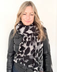 Woman wearing a black and white animal print patterned scarf
