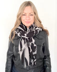 Woman wearing a black and white animal print patterned scarf