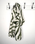 khaki and white zebra print striped scarf hanging on a rack against a white background
