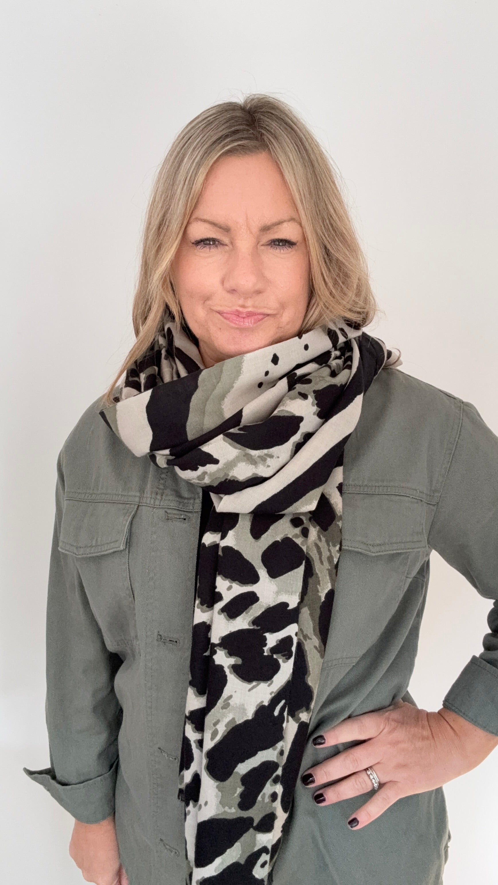 Woman wearing a khaki animal print midweight patterned scarf and khaki jacket for aurumn winter