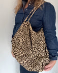 woman holding a leopard print tote bag