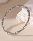 A silver bamboo bangle bracelet with a hinged opening