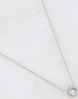 Silver necklace with a clear pendant on a light gray background