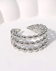 Stack of silver beaded rings on a light background