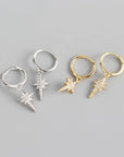 two pairs of silver and gold sparkly star hoop earrings.