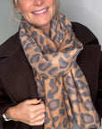 Woman wearing a brown suede coat and a mixed animal print scarf
