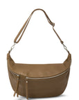 A woman wearing an XL taupe crossbody bag with silver hardware and an adjustable strap.