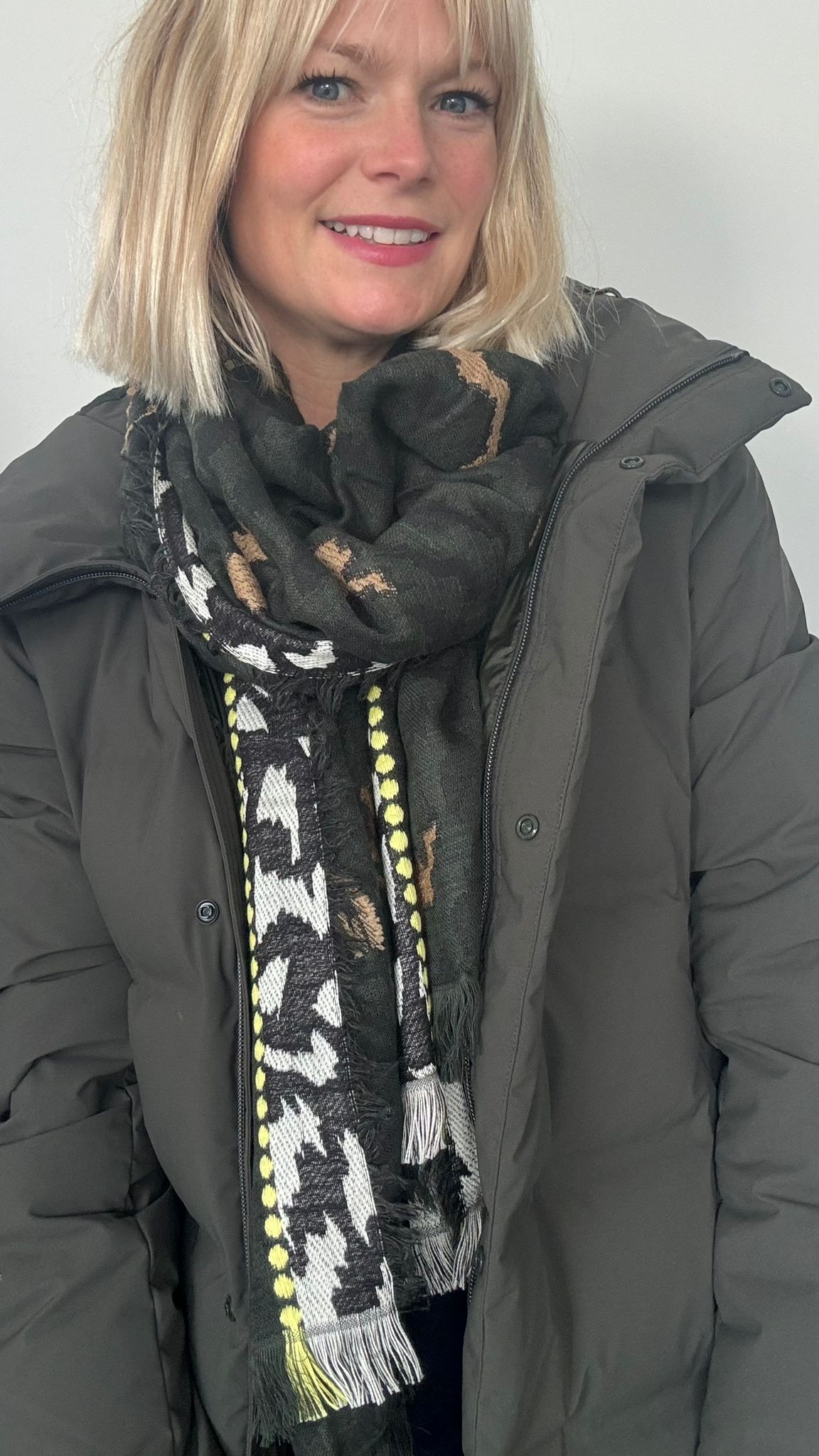 Woman wearing a dark coat and  luxury khaki animal print scarf patterned scarf for autumn winter