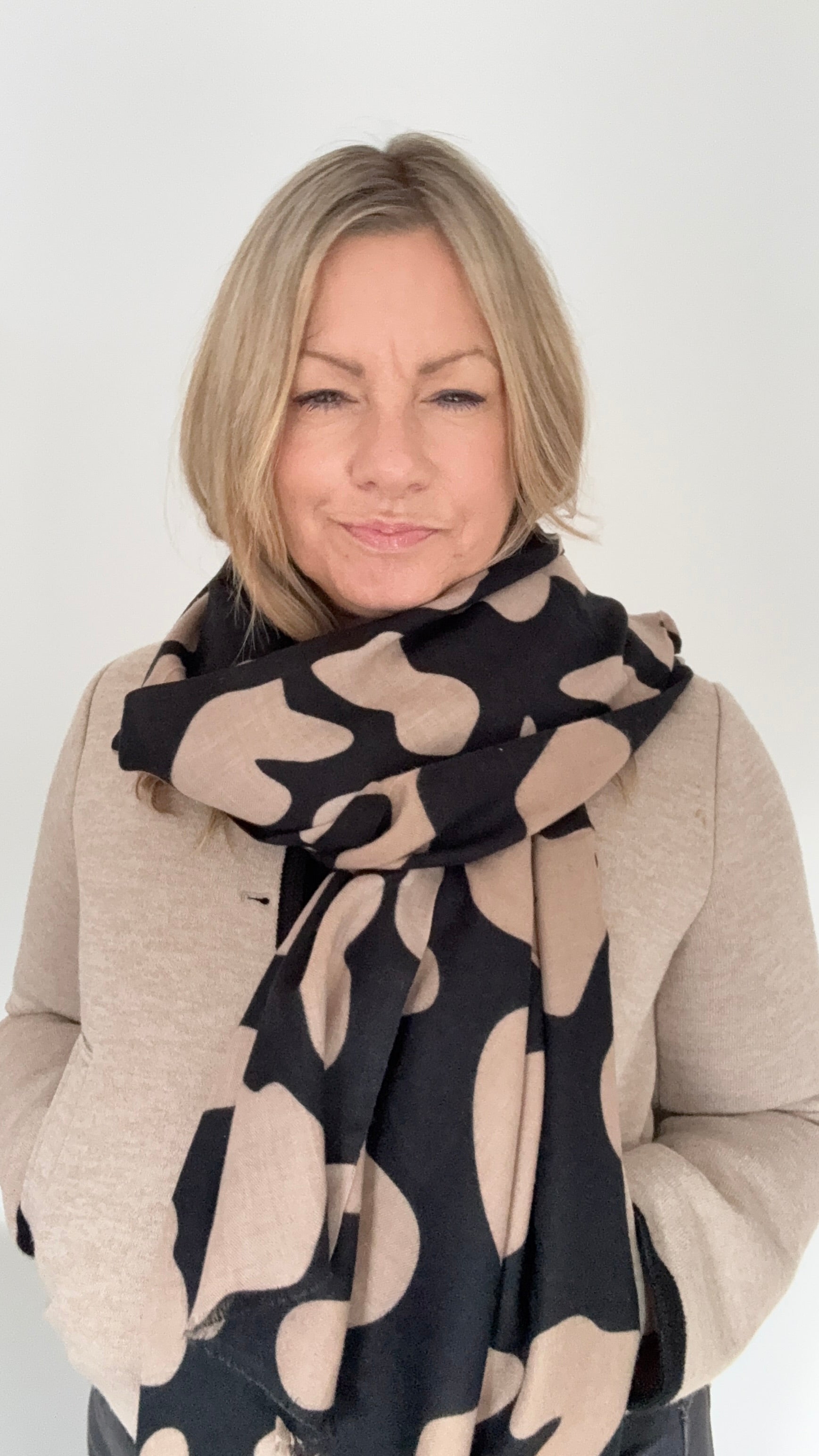 Woman wearing a black & camel animal print autumn winter scarf 