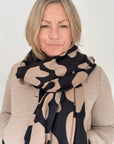 Woman wearing a black & camel animal print autumn winter scarf 