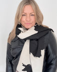 Woman wearing a black and white cow print patterned blanket scarf for Autumn Winter layering