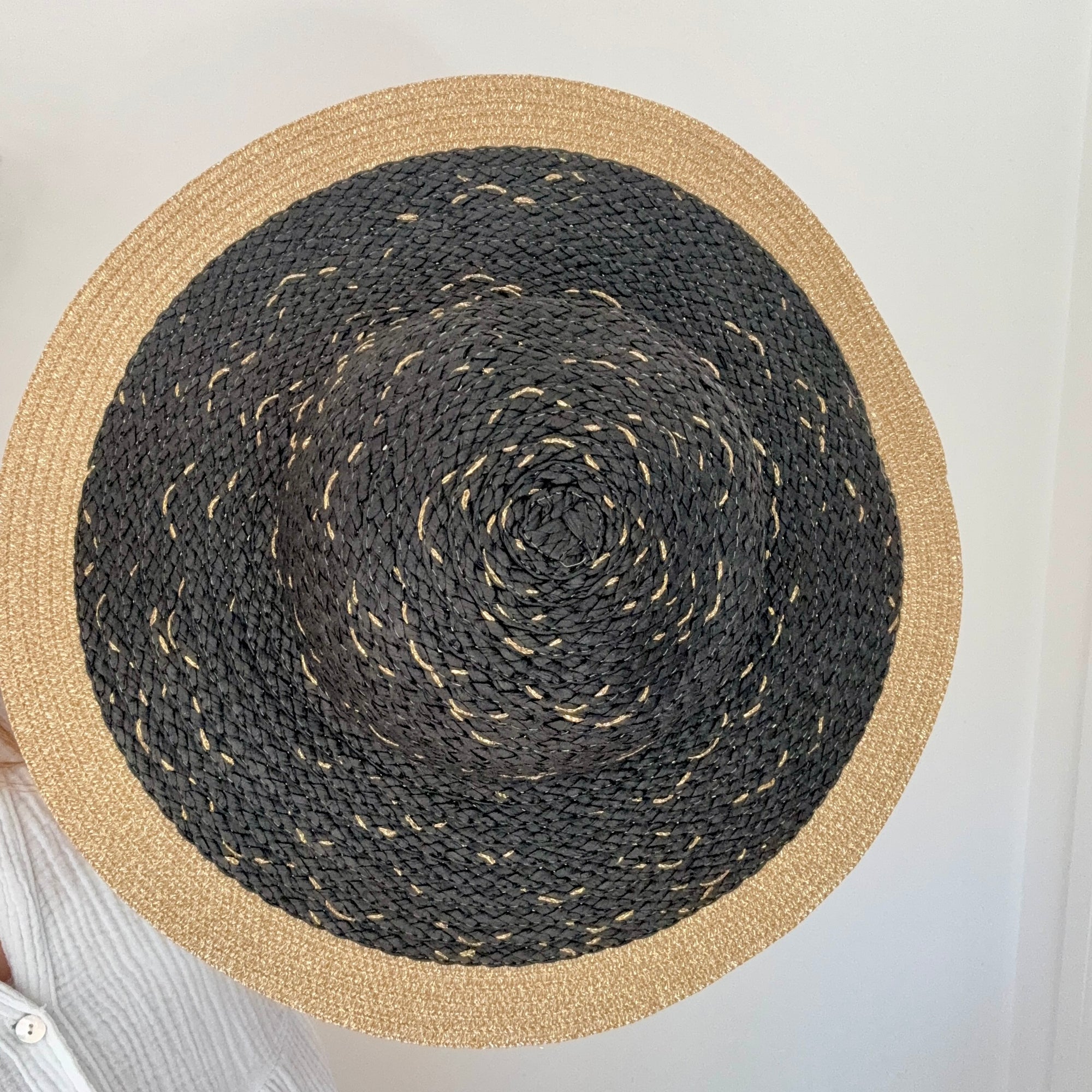 Round woven hat with black center and beige border 