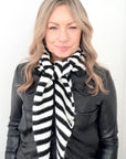Woman wearing a black and white striped scarf against a white background