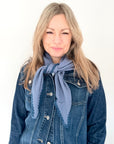 Woman wearing a denim jacket and blue cotton triangle scarf 