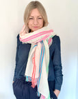 Woman wearing a colorful scarf  and denim shirt against a white background