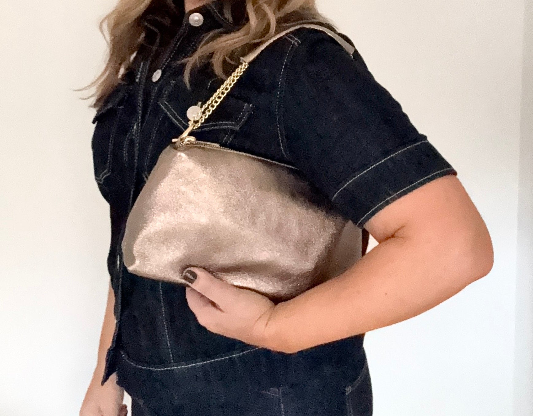 woman holding a bronze leather clutch / shoulder/ crossbody hand bag with a bronze shoulder strap 
