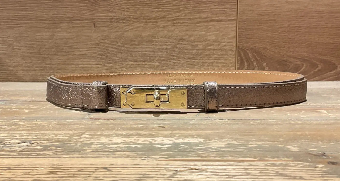 bronze narrow leather belt with gold buckle on a wooden surface