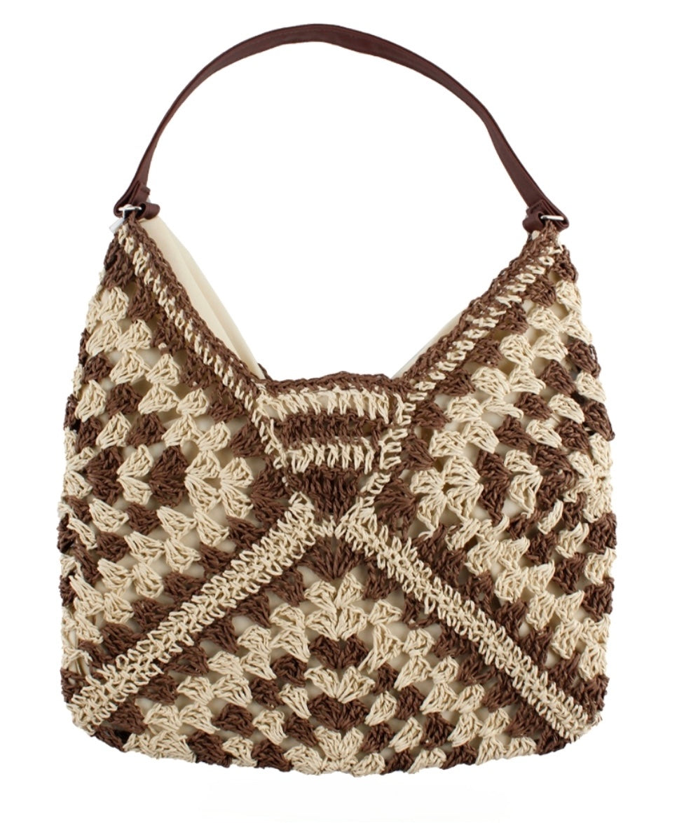 Brown and cream raffia shoulder bag on a plain background. 