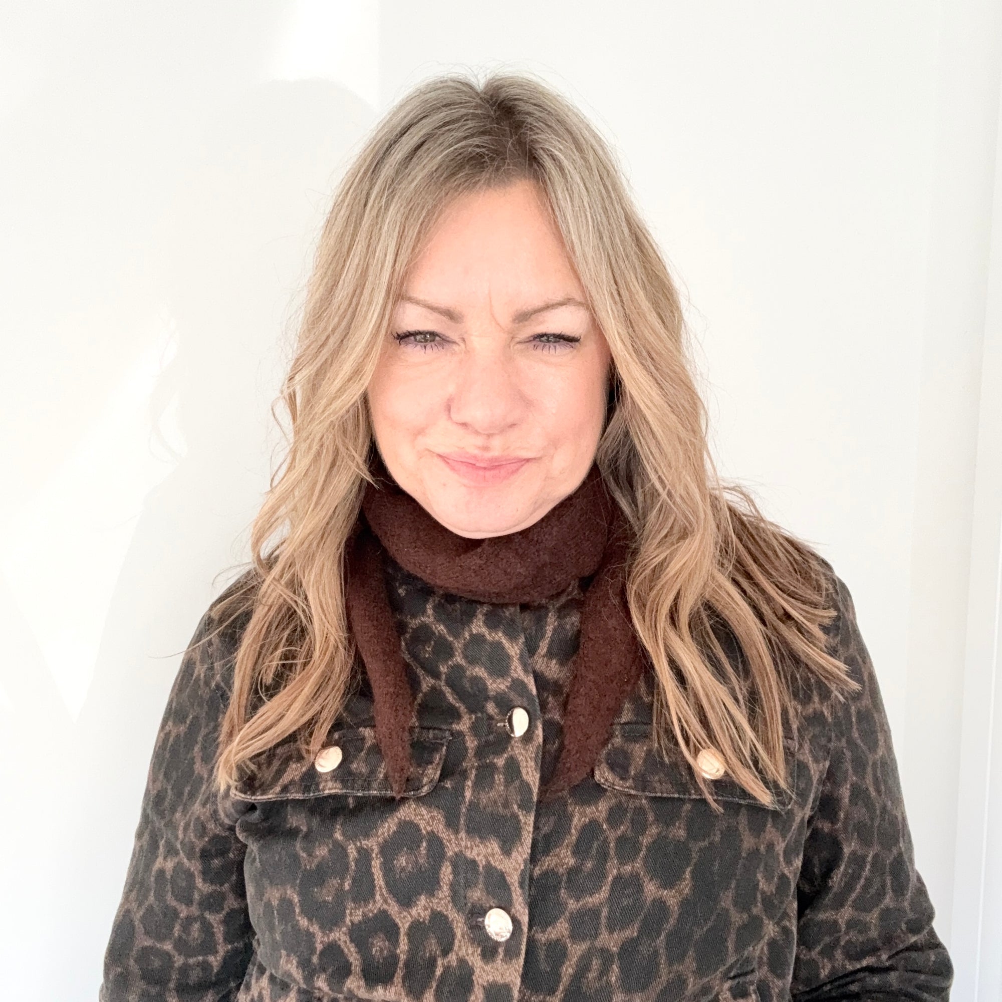 Woman wearing a leopard print coat and brown scarf 