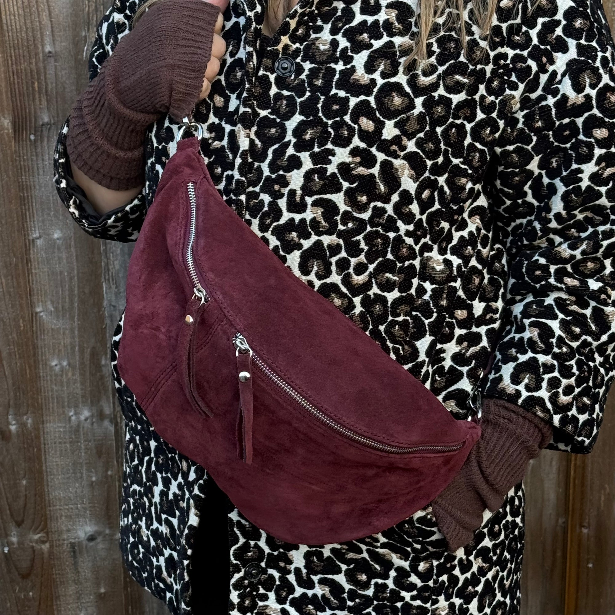 lady  wearing a leopard print coat with a burgundy suede large crossbody handbag 