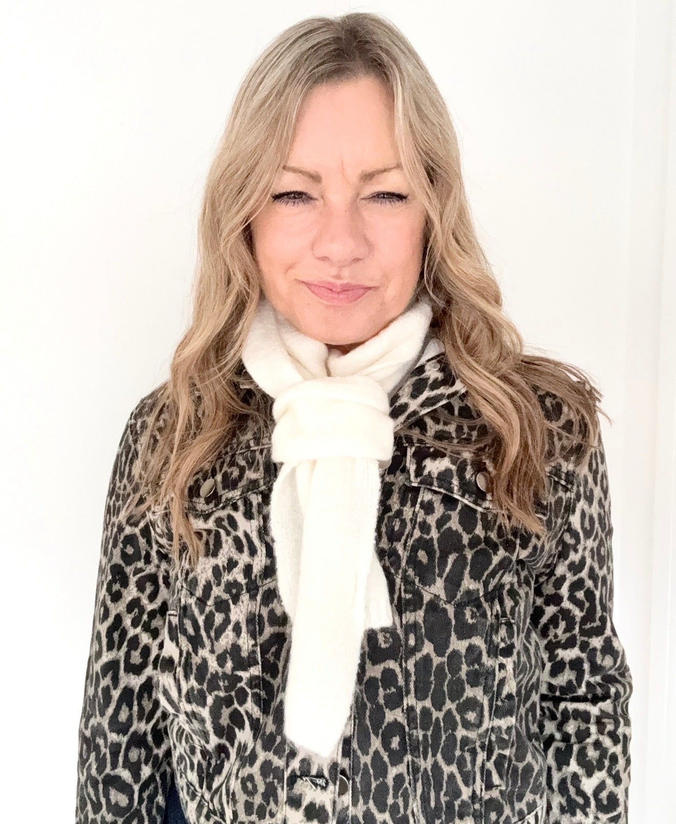 Woman wearing a leopard print coat and cream stripe knitted scarf