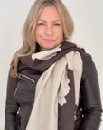 Woman wearing a brown leather jacket and a large scarf with a  Dark Brown & Cream Cow print pattern for Autumn Winter