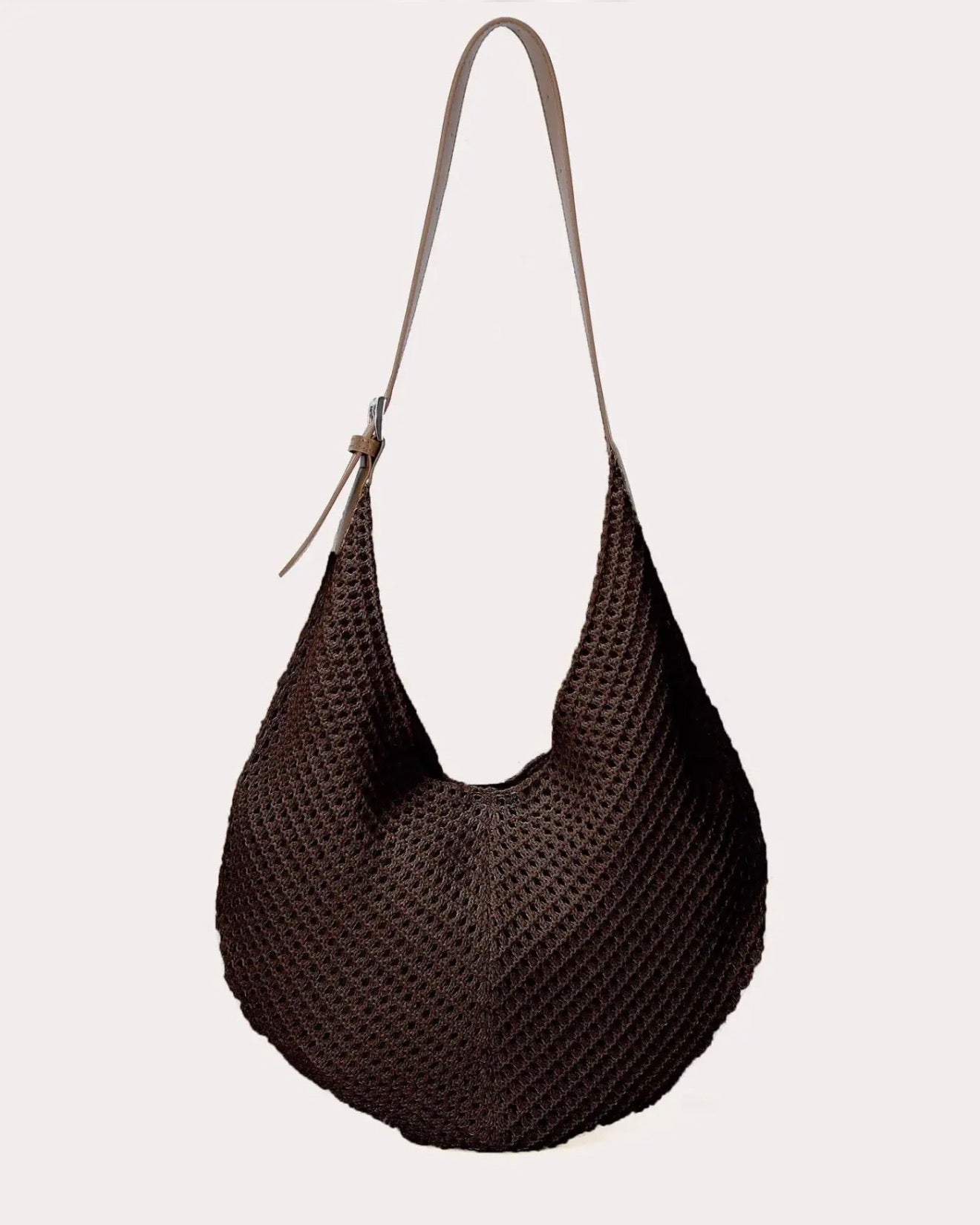 Dark brown knitted crossbody handbag against a white background. 