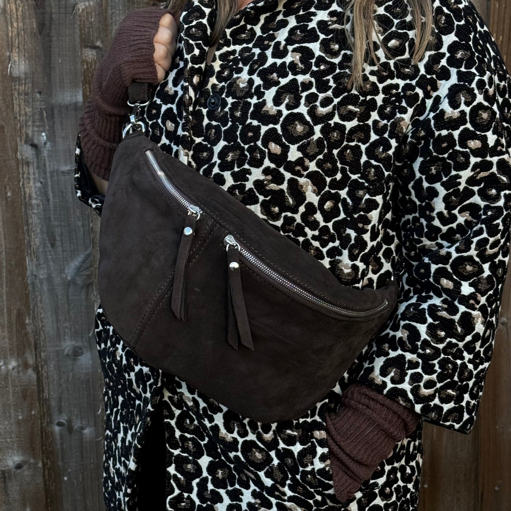 woman wearing a leopard print coat with a brown suede crossbody handbag 
