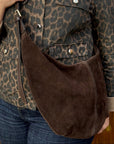 woman wearing a leopard print jacket with a dark brown suede XL crossbody swing bag. 