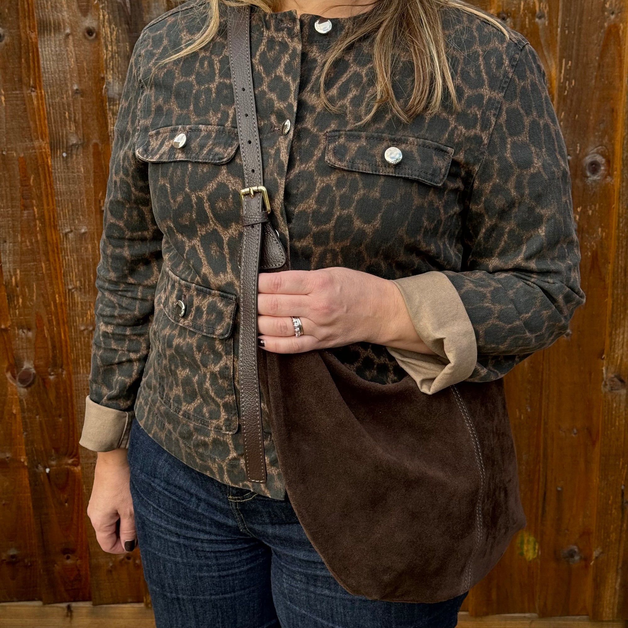 Woman wearing a leopard print jacket with a dark brown suede XL crossbody swing bag 