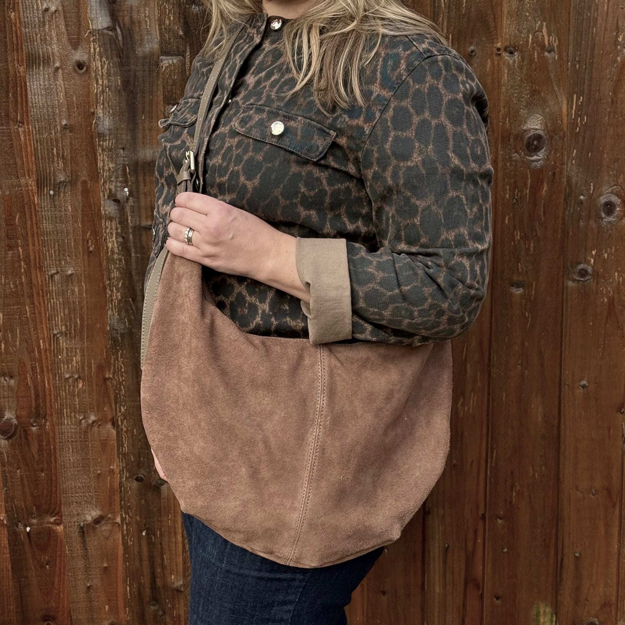 woman wearing a leopard print jacket holding a Dark taupe suede XL crossbody swing bag