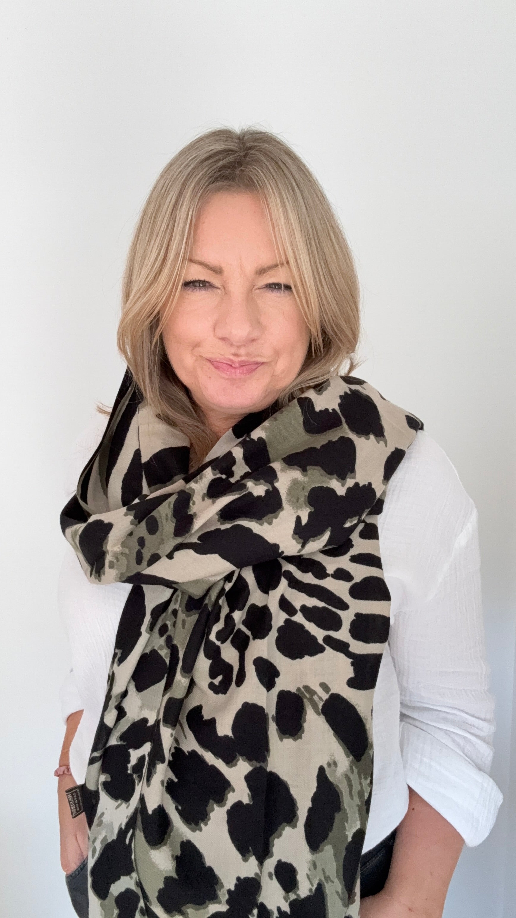 Woman wearing a khaki leopard print scarf for autumn winter
