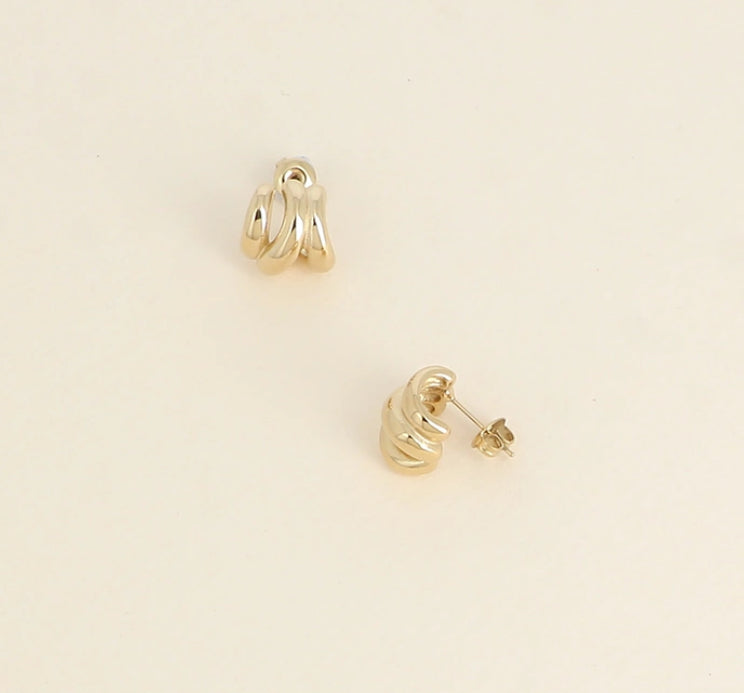 Gold hoop earrings on a beige background