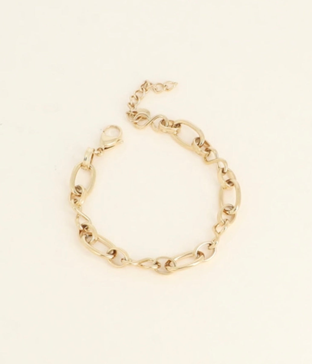 Gold chain bracelet on a beige background