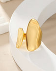 Gold chunky adjustable ring on a white plate 