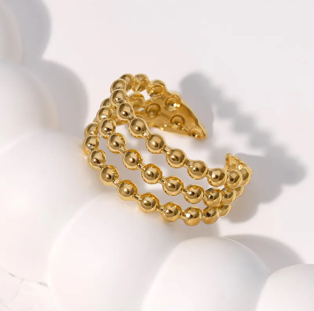 A gold-colored dotted adjustable ring made from gold-plated stainless steel