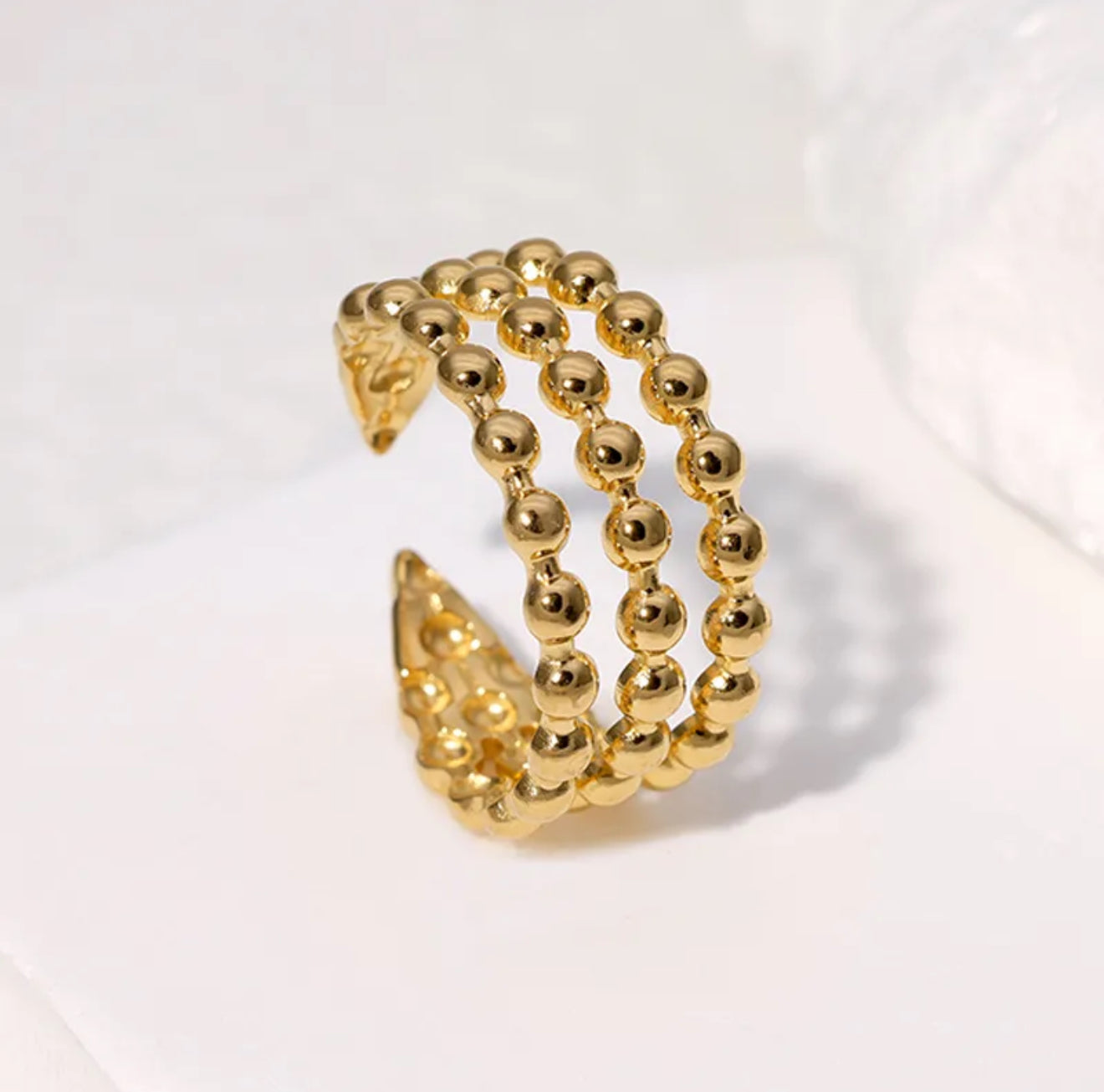 A gold-colored dotted adjustable ring made from gold-plated stainless steel