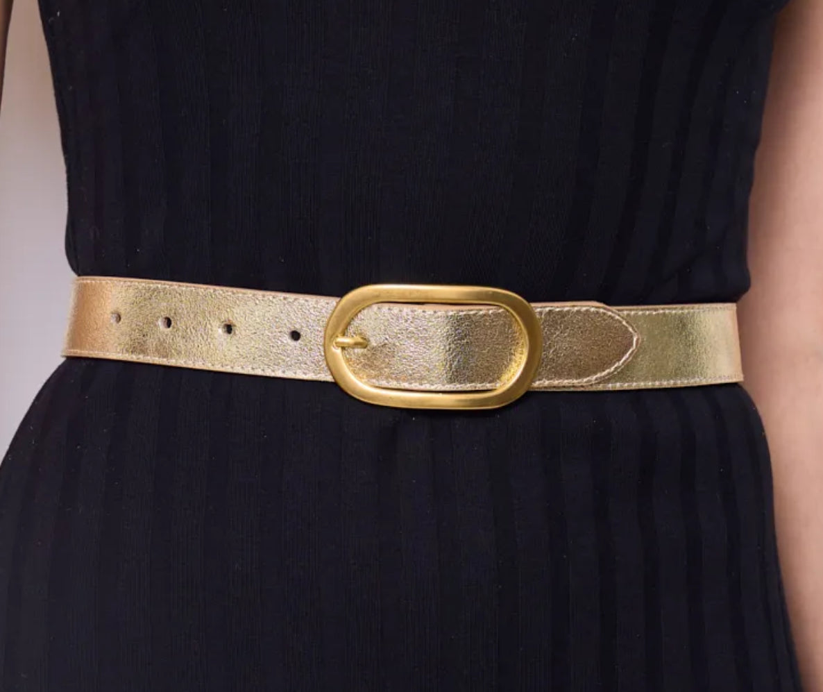 Gold belt with a large buckle on a black dress