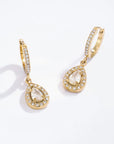 Gold sparkly teardrop earrings with clear stones on a white background
