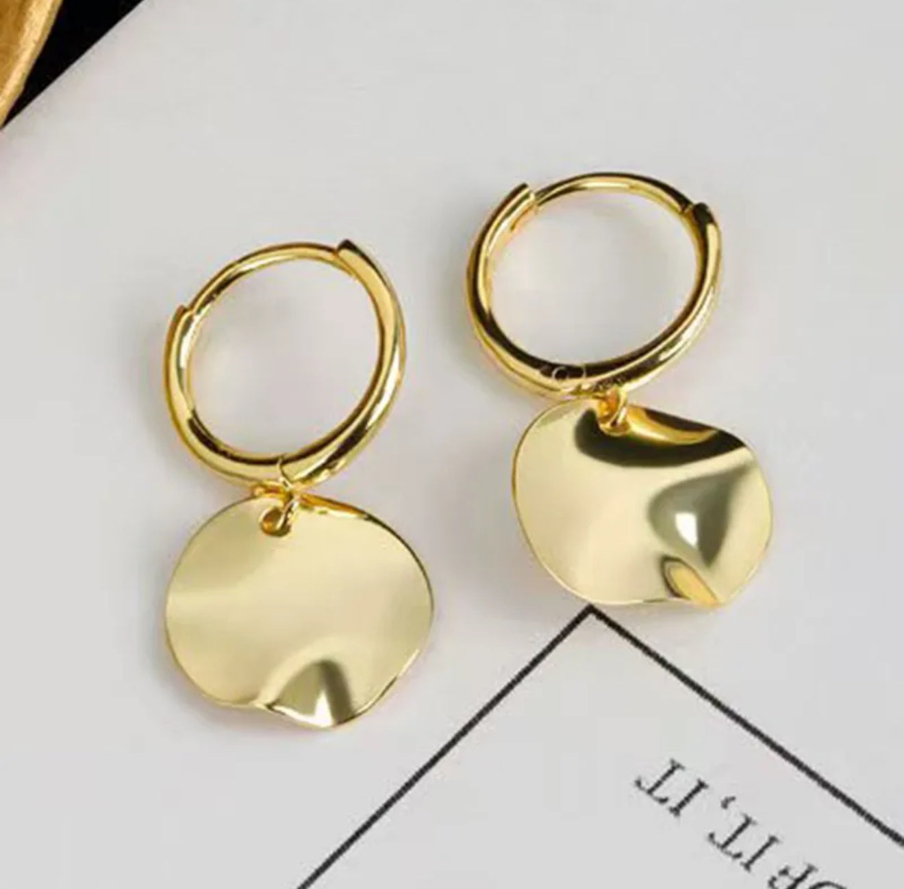 Gold hoop earrings with textured disk pendants 