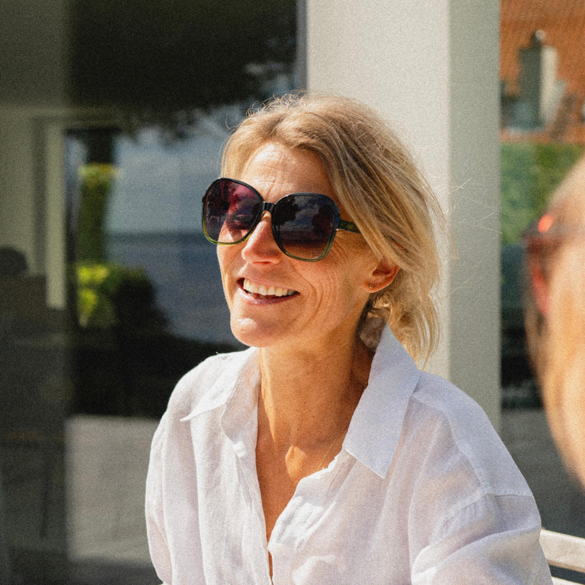 Woman wearing sunglasses and a white shirt outdoors