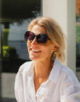 Woman wearing sunglasses and a white shirt outdoors