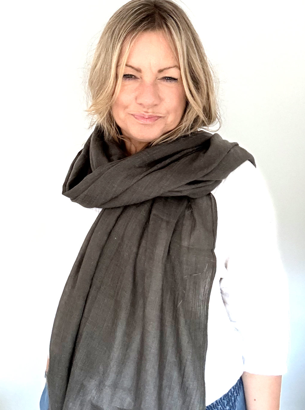 Woman wearing a green smoke plain scarf on a white background